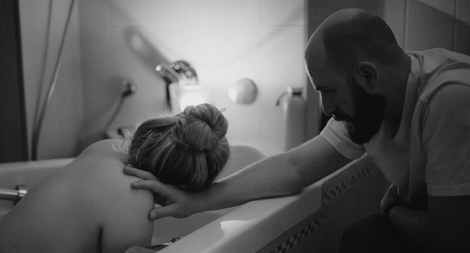 Mann hilft Partnerin während der Wehen